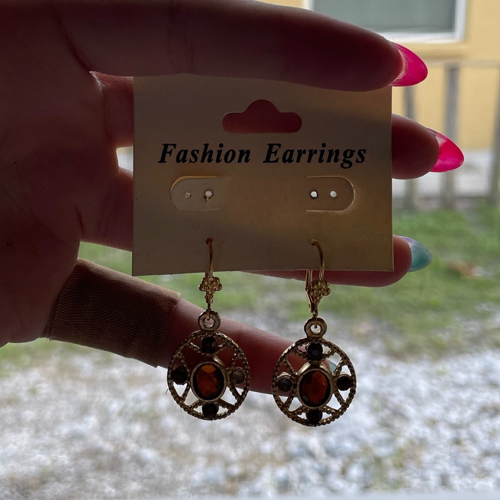 These are dangle earrings with orange gems
